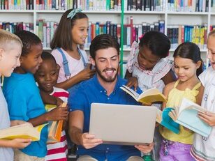 teacher sitting and reading with students